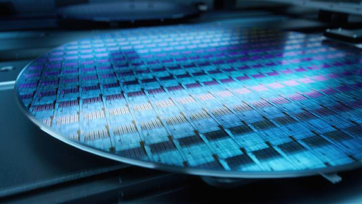 A close-up photograph capturing a silicon wafer in the midst of production at an advanced semiconductor foundry specializing in microchip manufacturing.